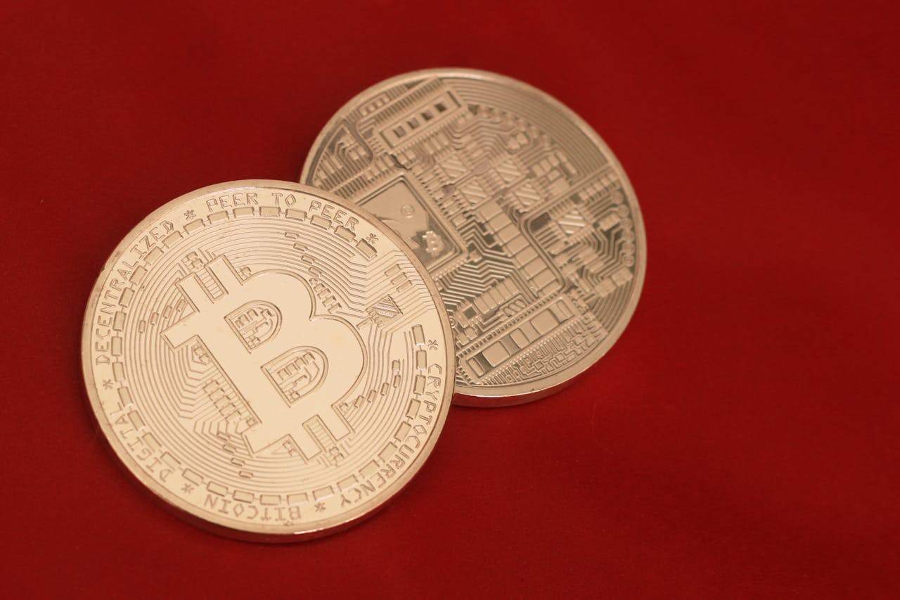 two bitcoins against red backdrop